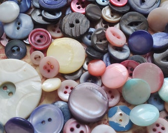 One Hundred plus (100) DYED Shell Buttons, Shell Buttons. Measure 1 1/2" and under. Wear to some.