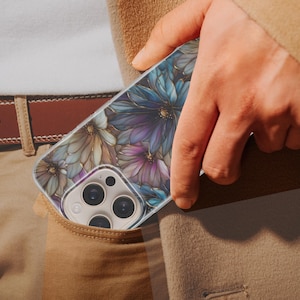 Puede incluir: Un tel&eacute;fono inteligente en una funda con estampado floral es parcialmente visible en un bolsillo. La funda presenta dise&ntilde;os de flores azules, moradas y doradas. La persona lleva un cintur&oacute;n marr&oacute;n y pantalones color caqui.