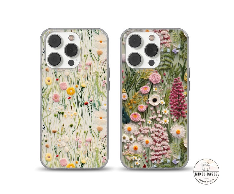 May include: Two phone cases featuring a floral design. The cases are clear and showcase a variety of flowers in shades of pink, white, and yellow. The flowers are embroidered on a white background.