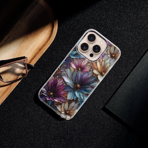 Puede incluir: Una funda transparente para tel&eacute;fono con un dise&ntilde;o floral en tonos morados, azules y dorados. La funda tiene un acabado brillante y est&aacute; dise&ntilde;ada para un smartphone. Las flores son detalladas y est&aacute;n dispuestas en un patr&oacute;n repetitivo.