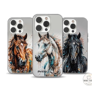 May include: Three clear phone cases with watercolor images of horses. The cases are for an iPhone with a camera bump. The cases have the names "Blaze", "Dolly", and "Mikel Cases" printed on them.