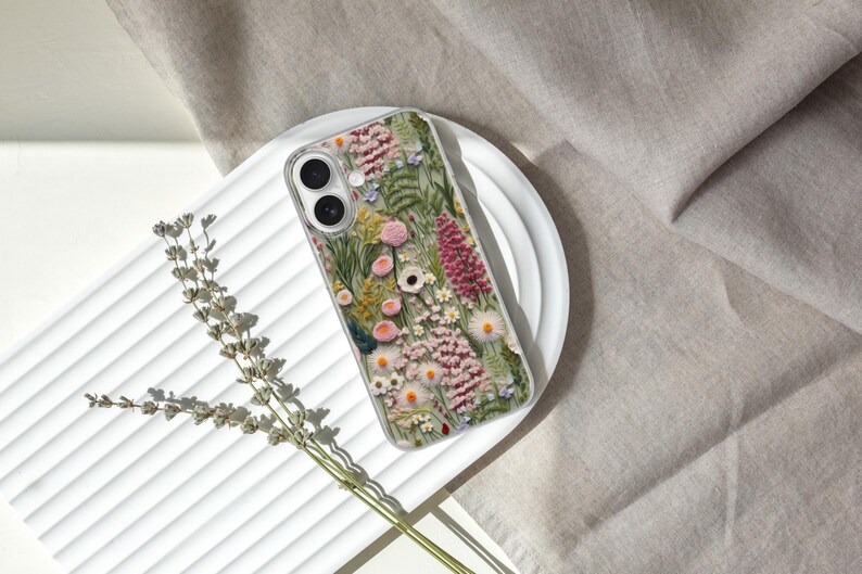 May include: A clear phone case with a floral design featuring pink, white, and green flowers. The case is designed to fit a smartphone.