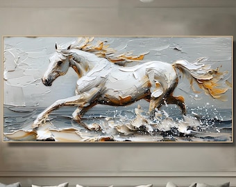 May include: A white horse with a flowing mane and tail runs through the water, depicted in a textured, abstract painting style. The painting has a gold frame and is displayed on a wall in a living room setting.