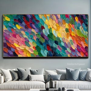 May include: A large, rectangular abstract painting in a gold frame. The artwork displays colourful brushstrokes in shades of red, pink, yellow, green, and blue. The text "StellarArtspace" is visible in the lower right corner.