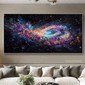 May include: A colorful abstract galaxy print with swirling colors of pink, purple, blue, and yellow on a black background. The print is framed and hanging on a wall in a living room setting.