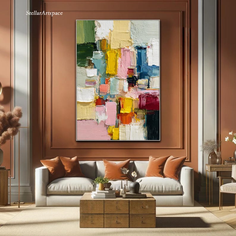 May include: Abstract oil painting with a textured surface, featuring a vibrant mix of colors including pink, yellow, green, and blue. The artwork is framed and hangs above a sofa in a living room setting. The text "StellarArtspace" is in the upper left corner.