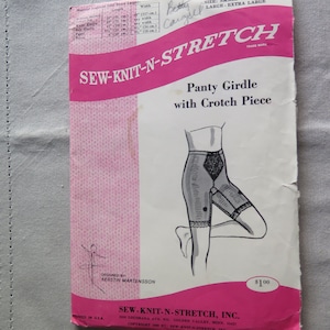 Könnte beinhalten: Vintage Schnittmuster für einen Panty-Gürtel mit Schrittteil, der Marke "SEW-KNIT-N-STRETCH". Das Muster hat ein rosa-weißes Design mit Maßen in cm und Zoll. Die Illustration zeigt das Kleidungsstück.