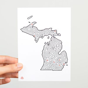 Op de afbeelding: Een zwart-witte lijntekening van de staat Michigan, ontworpen als een doolhof. Het doolhof heeft meerdere in- en uitgangen die zijn gemarkeerd met rode stippen.