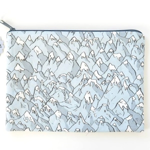 May include: A blue zippered pouch with a white mountain pattern. The pouch has a label that says "Handmade Zip Pouch Original Fabric by Marie Bouvier".