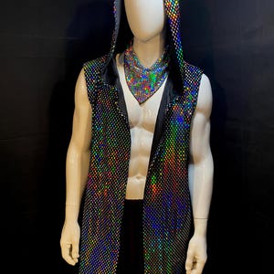 May include: A sleeveless hooded vest featuring a black mesh overlay with a reflective, multi-colored holographic dot pattern. The garment is worn with a matching triangular neck scarf, both displaying a shimmering, iridescent effect under light.
