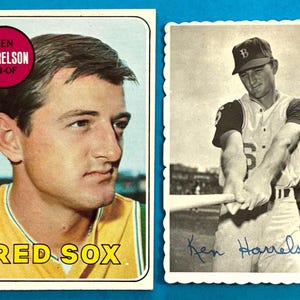 May include: Two vintage baseball cards featuring Ken Harrelson. One is a color card with a portrait and the text "RED SOX". The other is a black and white action shot of Harrelson holding a bat, with his signature.