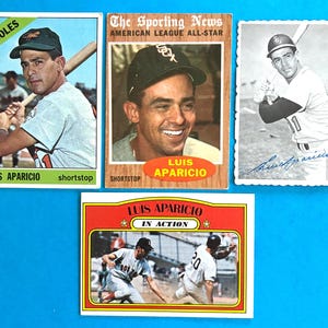 May include: Four vintage baseball cards featuring Luis Aparicio. One card shows him in an Orioles uniform, another as an American League All-Star, a black and white portrait with a signature, and an action shot with the text Luis Aparicio In Action.
