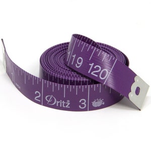 Puede incluir: Una cinta m&eacute;trica Dritz morada, desenrollada y enrollada. La cinta est&aacute; marcada en pulgadas hasta 304,8 cm. Los n&uacute;meros y las marcas son blancos. La cinta tiene una pieza final de metal.