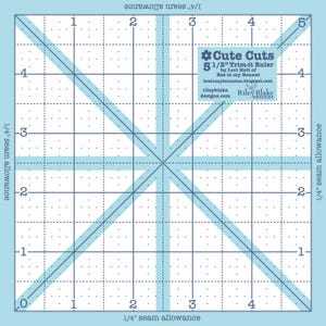 May include: A square, light blue quilting ruler with a grid pattern and diagonal lines. The ruler is labeled "Cute Cuts 5 1/2" Trim-it Ruler" and includes the text "by Lori Holt of Bee in my Bonnet".
