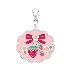 May include: A pink, scalloped-edge charm with a strawberry and flower design. The charm features a red bow, white flowers, and three strawberries. It has a silver-coloured clasp for attachment.