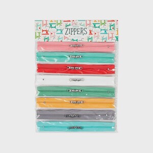 May include: A pack of eight assorted colored zippers in a clear plastic sleeve. The header card features a repeating pattern of sewing machines and the text "Happy ZIPPERS". The zippers are pink, teal, red, white, green, yellow, gray, and light blue.