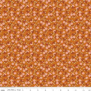 Pode incluir: Uma estampa de tecido com um padrão repetitivo de pequenas flores rosa claro e caules marrom-escuros sobre um fundo laranja queimado sólido. Uma régua branca na parte inferior mostra uma escala de 12 polegadas, com o texto Riley Blake Designs impresso.