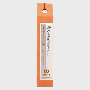 May include: Orange rectangular package of quilting needles. The package has a label with the text "#9 Quilting Needles Between" and "Hiroshima Needles". The package also has the brand name "Tulip" and is made in Japan.