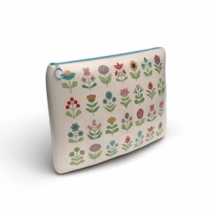 Peut inclure: Une pochette zippée de couleur crème avec un motif répété de fleurs colorées et stylisées. Les fleurs sont de différentes couleurs, dont le rouge, le rose, le bleu et le jaune, avec des tiges et des feuilles vertes. La fermeture éclair est bleu clair.