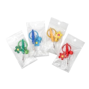 May include: Four colorful seam rippers packaged in clear plastic bags. Each ripper has a different colored handle and decorative charm: green flower, blue bear, yellow flower, and red flower. The seam rippers are for sewing and crafting.