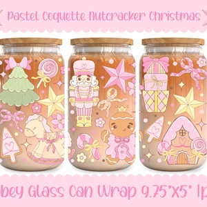 May include: Three glass can wraps with wooden lids, featuring pastel Christmas designs. Each wrap showcases a different design: a Christmas tree, a nutcracker, and wrapped gifts. The text "Pastel Coquette Nutcracker Christmas" and "Libbey Glass Can Wrap 9.75"x5" lpng" are visible.