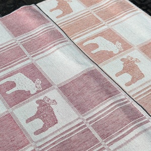 Puede incluir: Dos toallas de cocina a cuadros rosa y blanco con un dise&ntilde;o de alce blanco. Las toallas est&aacute;n hechas de un tejido suave y tejido.