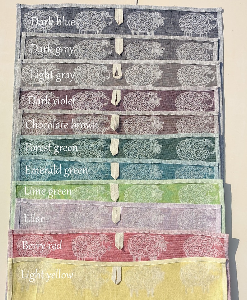 May include: A set of 11 tea towels featuring a sheep design in various colours, including dark blue, dark grey, light grey, dark violet, chocolate brown, forest green, emerald green, lime green, lilac, berry red, and light yellow.
