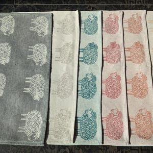 Puede incluir: Conjunto de 10 toallas de cocina con diseño de oveja. Las toallas son de varios colores, incluyendo gris, azul verdoso, rosa y beige.