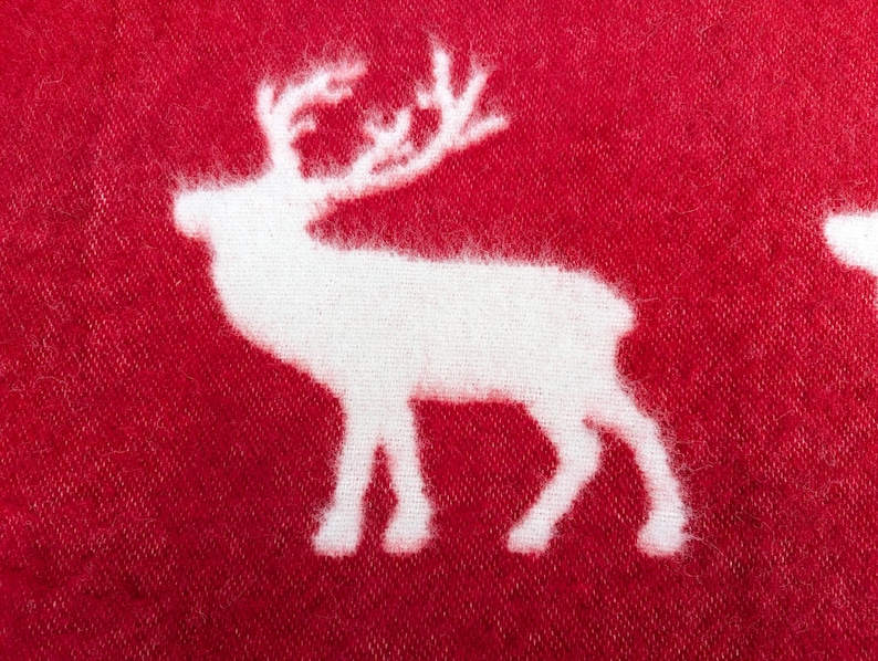 May include: White reindeer silhouette on a red fabric background.