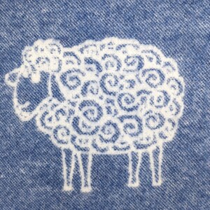 May include: A white sheep with a curly wool pattern is embroidered on a blue denim fabric.