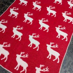 May include: Red throw blanket with a white reindeer pattern.
