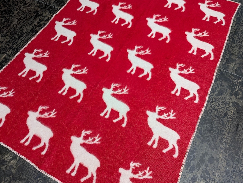 May include: Red throw blanket with a white reindeer pattern.