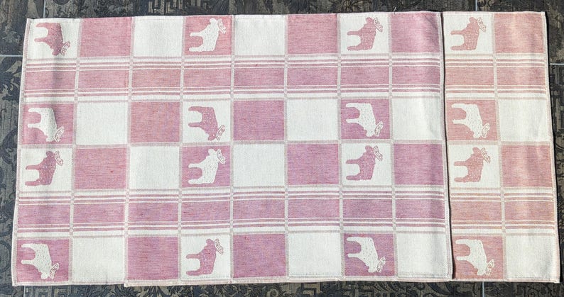 Puede incluir: Dos toallas de cocina a cuadros rosa y blanco con un dise&ntilde;o de reno blanco. Las toallas est&aacute;n hechas de un tejido suave y tejido.