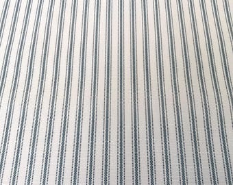 May include: White fabric with thin, dark blue stripes. The stripes are evenly spaced and have a subtle dotted pattern.
