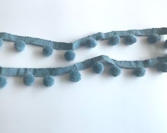 May include: A light blue trim with pom poms. The trim is made of a soft, fuzzy material and is perfect for adding a touch of whimsy to any project.