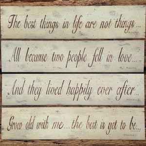 May include: Four wooden signs with a distressed white paint finish and brown lettering. The signs feature a quote about love: "The best things in life are not things... All because two people fell in love... And they lived happily ever after... Grow old with me... the best is yet to be..."