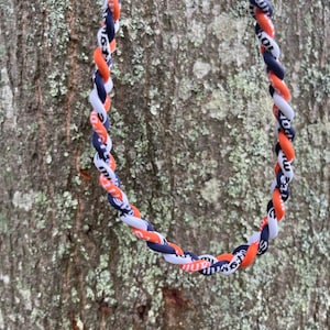 May include: A black, white, and orange braided lanyard with the text "Elite Sports" repeated on the strands.