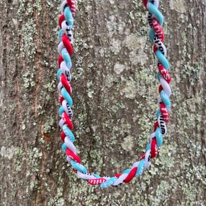 May include: A braided lanyard with red, white, and blue stripes. The lanyard has the words "Family Sports" printed on it.
