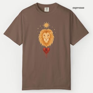 Comfort Colors Espresso t-shirt with a soft watercolor Leo lion design, golden sunburst, and a dripping red heart symbolizing the Leo zodiac sign.