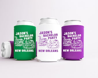 May include: Three beverage can coolers in green, white, and purple, each with a white design and text. The design features cartoon alligators and the text "JASON'S BACHELOR PARTY NEW ORLEANS". One cooler is lying on its side.