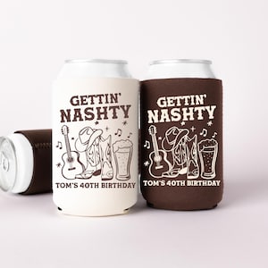 May include: Two can coolers, one cream and one brown, with the text "GETTIN' NASHTY" and a country music-themed graphic. The design includes a guitar, cowboy boots, a cowboy hat, and a beer. The text "TOM'S 40TH BIRTHDAY" is also included.