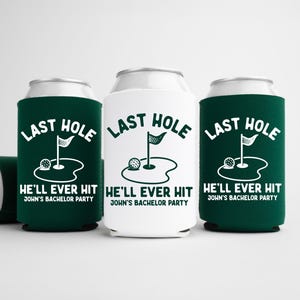 May include: Three can coolers, two in dark green and one in white, with a golf-themed design. The text reads "LAST HOLE HE'LL EVER HIT" and "JOHN'S BACHELOR PARTY". A fourth can cooler is partially visible.