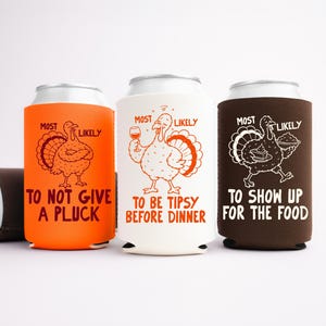 May include: Three foam can coolers in orange, white, and brown. The orange cooler features a turkey and the text MOST LIKELY TO NOT GIVE A PLUCK. The white one shows a turkey with a wine glass and MOST LIKELY TO BE TIPSY BEFORE DINNER. The brown one shows a turkey with food and MOST LIKELY TO SHOW UP FOR THE FOOD.