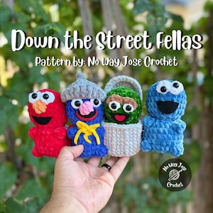 May include: Four crocheted plush figures titled Down the Street Fellas, Pattern by: No Way Jose Crochet. The set includes a red figure, a blue figure with a gray hat and yellow tie, a green figure in a gray trash can, and a blue monster figure.