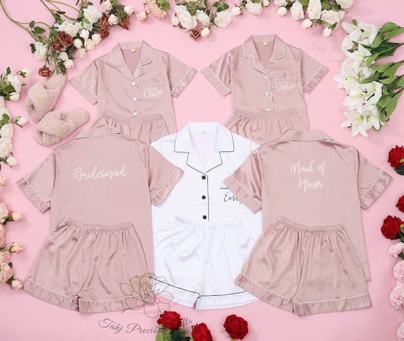 Puede incluir: Cuatro conjuntos de pijama de sat&eacute;n rosa con mangas cortas y pantalones cortos. Los conjuntos est&aacute;n bordados con las palabras "Bride", "Maid of Honor", "Bridesmaid" y "Ember".