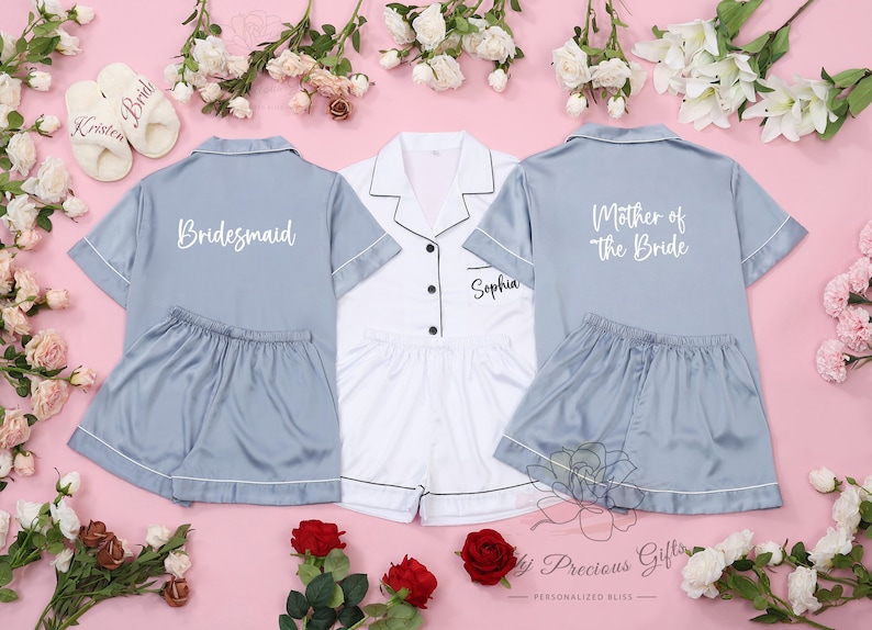 May include: Three matching pajama sets in blue and white with personalized text. The blue sets have white text that says "Bridemaid" and "Mother of the Bride". The white set has black text that says "Sophia".