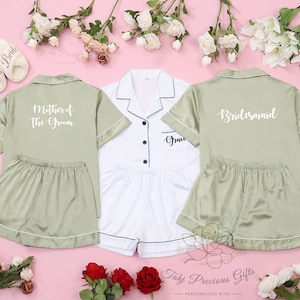 May include: Three satin pajamas sets in green and white with short sleeves and shorts. The sets have different text on the front: "Mother of the Groom", "Bride", and "Bridesmaid".