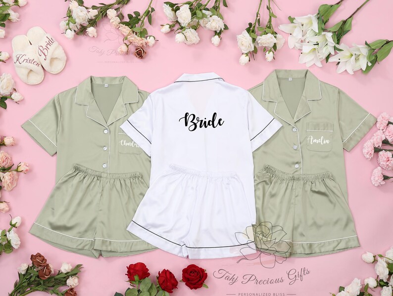 Puede incluir: Tres conjuntos de pijama de sat&eacute;n a juego con mangas cortas y pantalones cortos. El conjunto de la novia es blanco con ribetes negros y dice "Bride" en escritura negra. Los otros dos conjuntos son verde salvia con ribetes blancos y est&aacute;n personalizados con nombres.