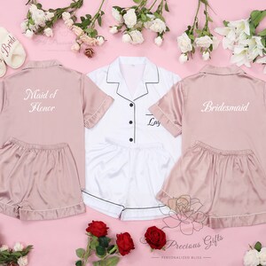 May include: Three satin pajama sets in pink and white with embroidered text. One set says "Maid of Honor", one says "Bride", and one says "Bridesmaid".