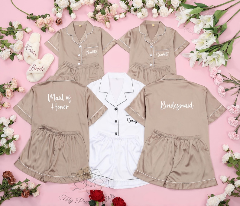 Puede incluir: Cuatro conjuntos de pijamas a juego en color marr&oacute;n claro con ribetes blancos. Las pijamas tienen mangas cortas y pantalones cortos. Cada conjunto tiene un t&iacute;tulo diferente bordado en la espalda: "Bride", "Maid of Honor", "Bridesmaid" y "Evelyn".